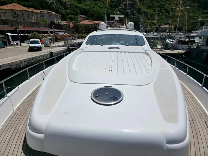 Evazione Yacht Photos Pics 2005 Pershing 67 yacht docked at a marina, showcasing sleek design and spacious deck.