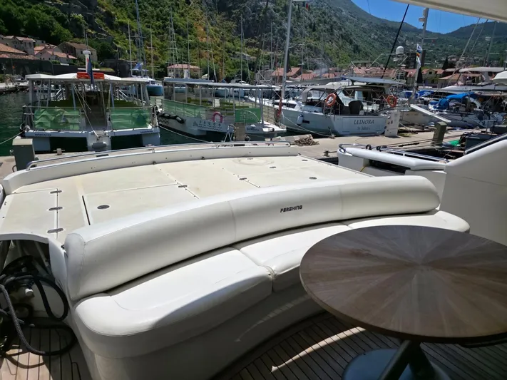 Evazione Yacht Photos Pics Luxury 2005 Pershing 67 yacht docked in scenic marina with lush hills.