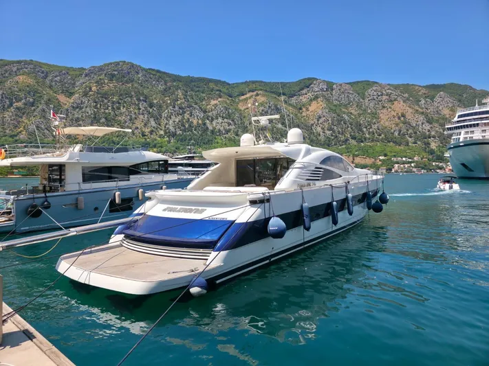 Evazione Yacht Photos Pics Luxury 2005 Pershing 67 yacht docked in scenic marina with mountainous backdrop.