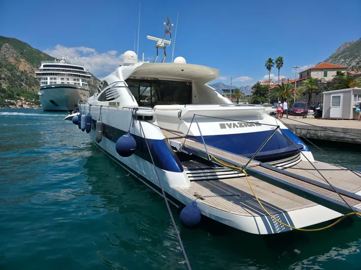 Evazione Yacht Photos Pics Luxury 2005 Pershing 67 yacht docked in scenic harbor with cruise ship nearby.