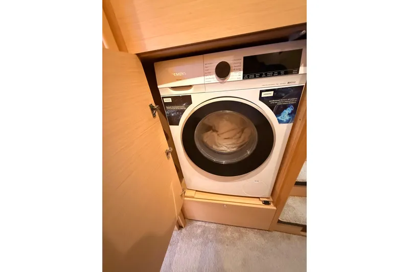 Chicago Yacht Photos Pics Washing machine inside Lagoon 52 F yacht, 2020 model, in a wooden cabinet.