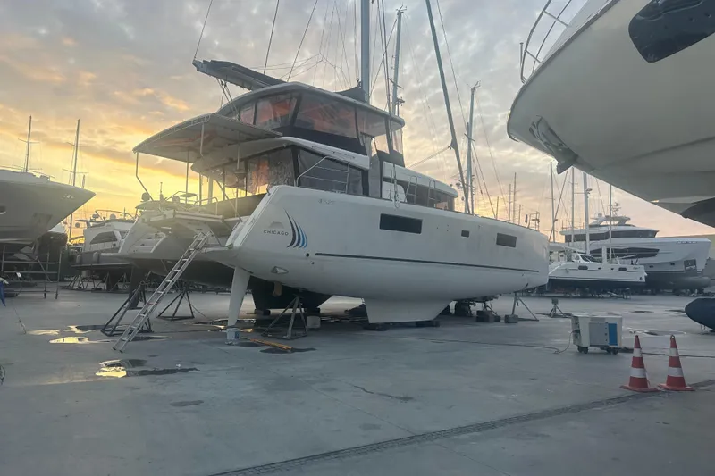 Chicago Yacht Photos Pics 2020 Lagoon 52 F catamaran in a marina at sunset, surrounded by other boats.
