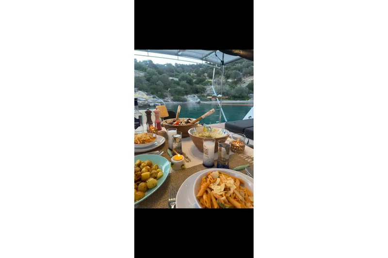 Chicago Yacht Photos Pics Dining setup on Lagoon 52 F yacht, featuring pasta and scenic ocean view.