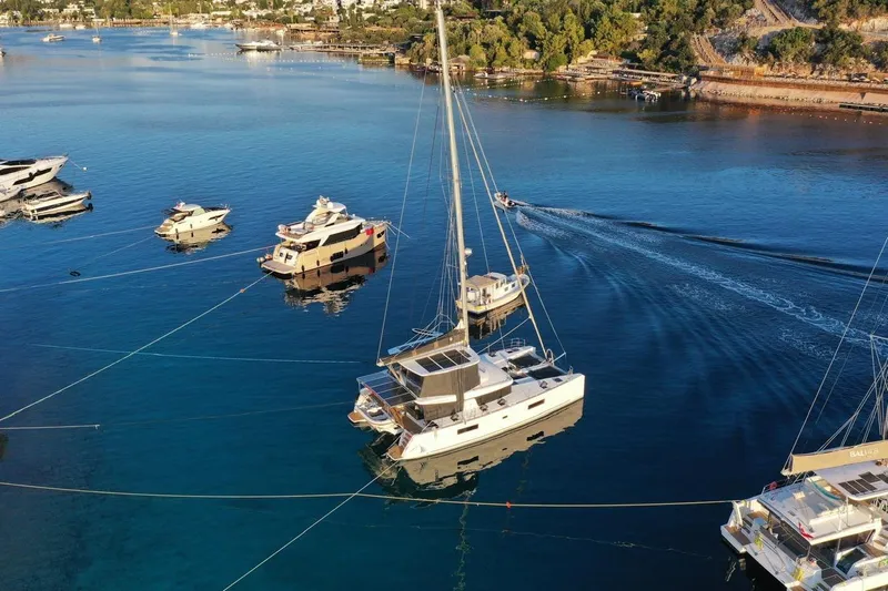Chicago Yacht Photos Pics Aerial view of 2020 Lagoon 52 F catamaran anchored among boats in a serene bay.