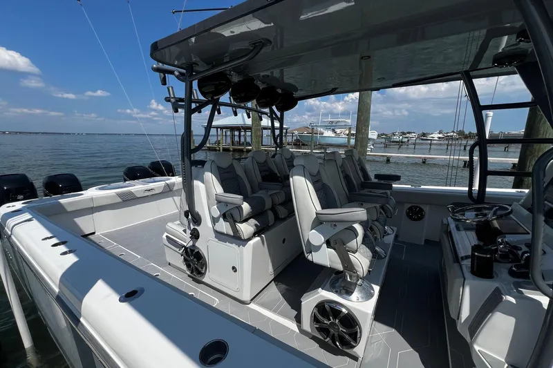 Reel Deployment Yacht Photos Pics Luxurious 2022 Invincible 46 Catamaran with plush seating, docked by serene waters.