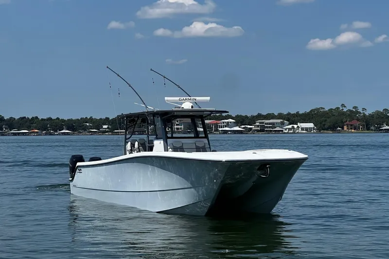 Reel Deployment Yacht Photos Pics 2022 Invincible 46 Catamaran on calm water, clear sky, coastal background.
