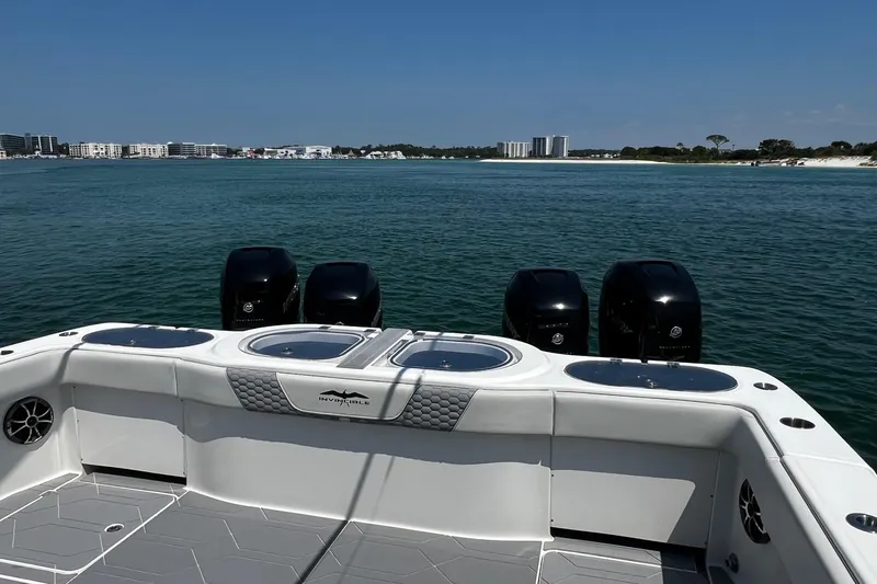 Reel Deployment Yacht Photos Pics 2022 Invincible 46 Catamaran with four engines, cruising near a coastal city skyline.