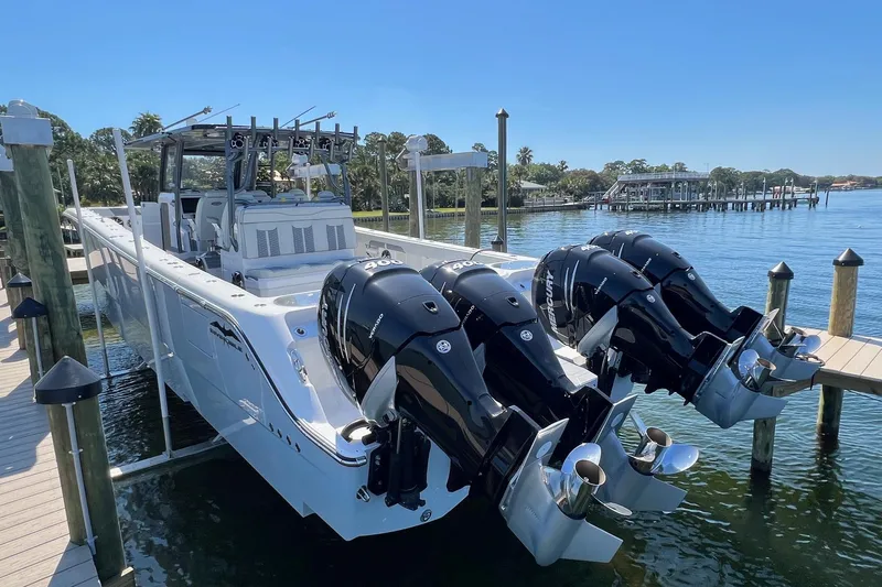 Reel Deployment Yacht Photos Pics 2022 Invincible 46 Catamaran with powerful outboard engines docked by the water.