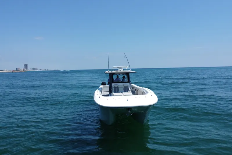 Reel Deployment Yacht Photos Pics 2022 Invincible 46 Catamaran on open sea with city skyline in background.