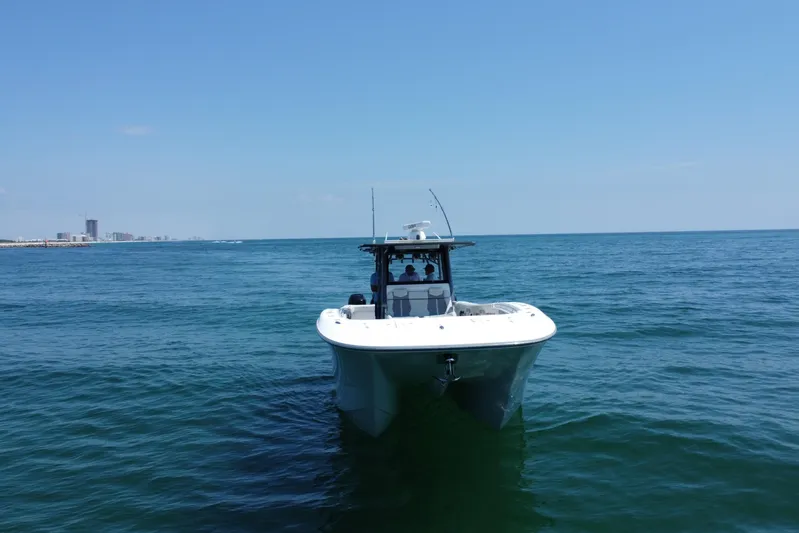 Reel Deployment Yacht Photos Pics 2022 Invincible 46 Catamaran on open sea with city skyline in background.