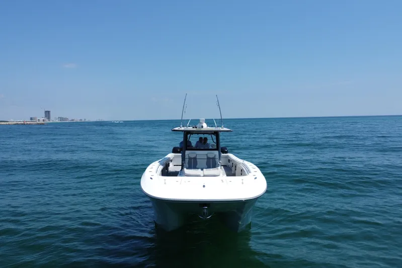 Reel Deployment Yacht Photos Pics 2022 Invincible 46 Catamaran on open sea with city skyline in background.