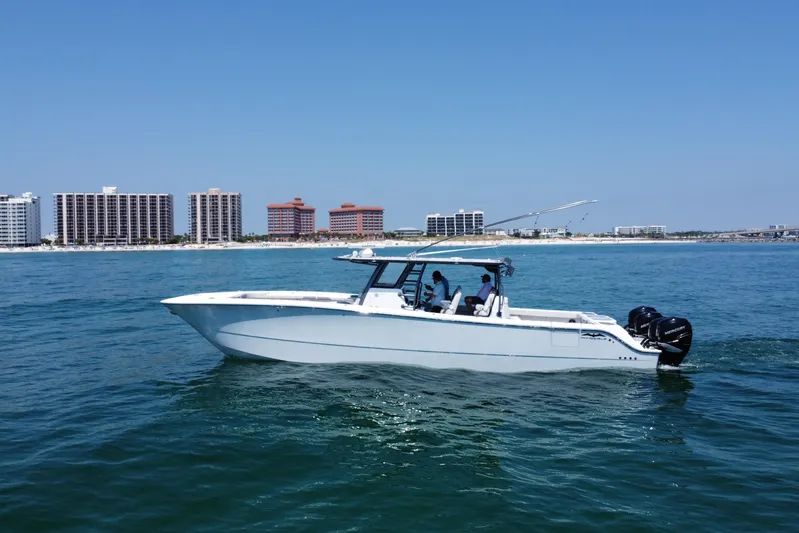 Reel Deployment Yacht Photos Pics Invincible 46 Catamaran 2022 cruising near coastal city skyline on a sunny day.