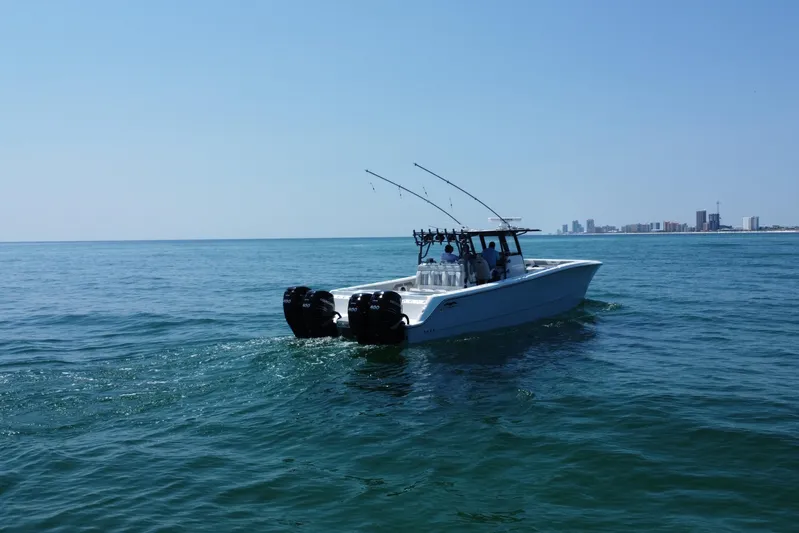 Reel Deployment Yacht Photos Pics 2022 Invincible 46 Catamaran cruising on open water with city skyline in background.