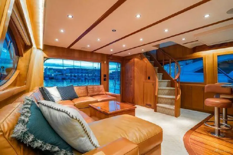 Desperado Yacht Photos Pics Luxurious interior of 2008 Hatteras 77 Enclosed Bridge yacht with leather seating and wooden finishes.
