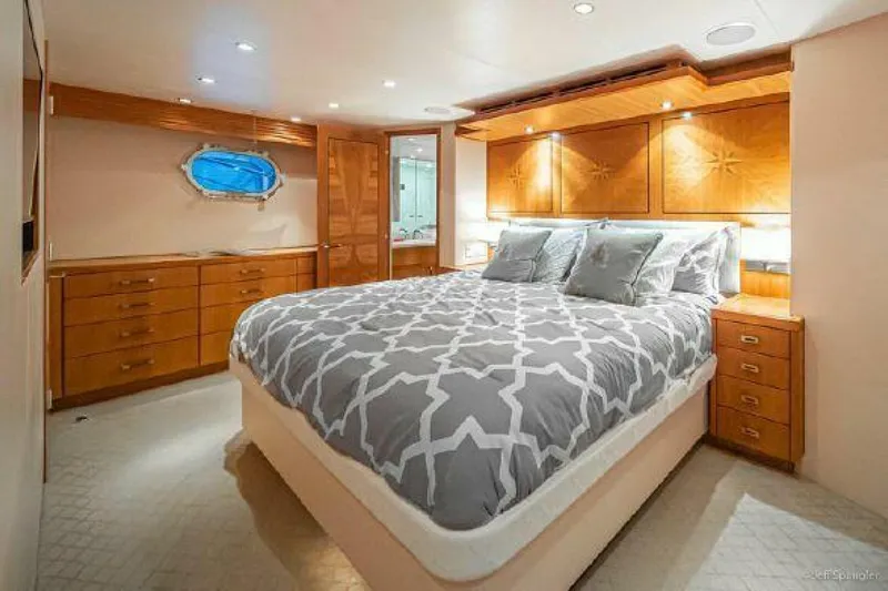 Desperado Yacht Photos Pics Luxurious bedroom in 2008 Hatteras 77 Enclosed Bridge yacht with wood cabinetry and large bed.