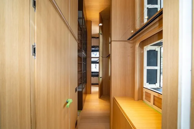 Presence Yacht Photos Pics Narrow wooden hallway inside 2026 Cantiere Delle Marche 130.37 yacht, featuring modern design elements.