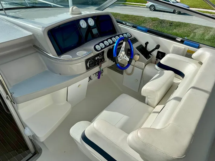 Tony Montana Yacht Photos Pics 1999 Formula 400 Super Sport boat cockpit with white seating and blue steering wheel.