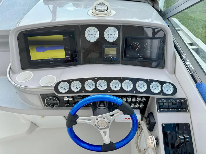 Tony Montana Yacht Photos Pics 1999 Formula 400 Super Sport dashboard with blue steering wheel and navigation displays.