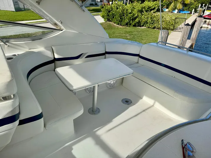 Tony Montana Yacht Photos Pics 1999 Formula 400 Super Sport boat interior with white seating and table, dockside view.