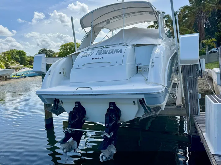 Tony Montana Yacht Photos Pics 1999 Formula 400 Super Sport boat docked, rear view, with outboard motors, sunny day.