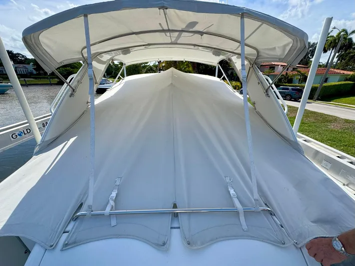Tony Montana Yacht Photos Pics 1999 Formula 400 Super Sport boat with white canopy and cover, docked near a canal.