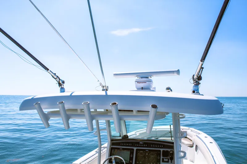  Yacht Photos Pics 2017 Boston Whaler 330 Outrage boat with fishing rod holders, ocean view, and clear blue sky.