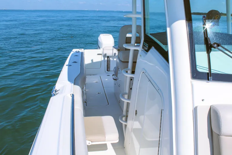  Yacht Photos Pics 2017 Boston Whaler 330 Outrage boat on calm ocean waters, showcasing sleek design.