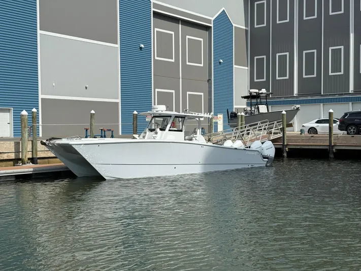  Yacht Photos Pics Freeman 38 boat docked at marina, 2025 model, with blue and gray building backdrop.