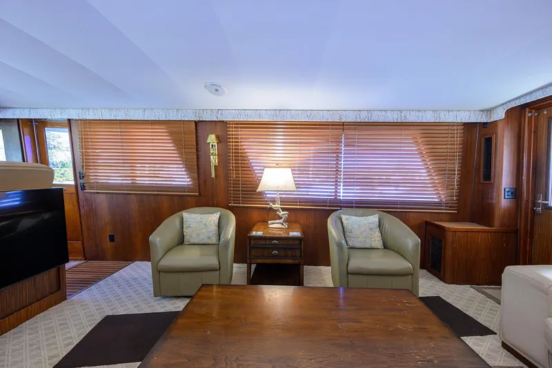 Phantom Yacht Photos Pics Interior of 1987 Hatteras 63 Motor Yacht with cozy seating and wooden decor.