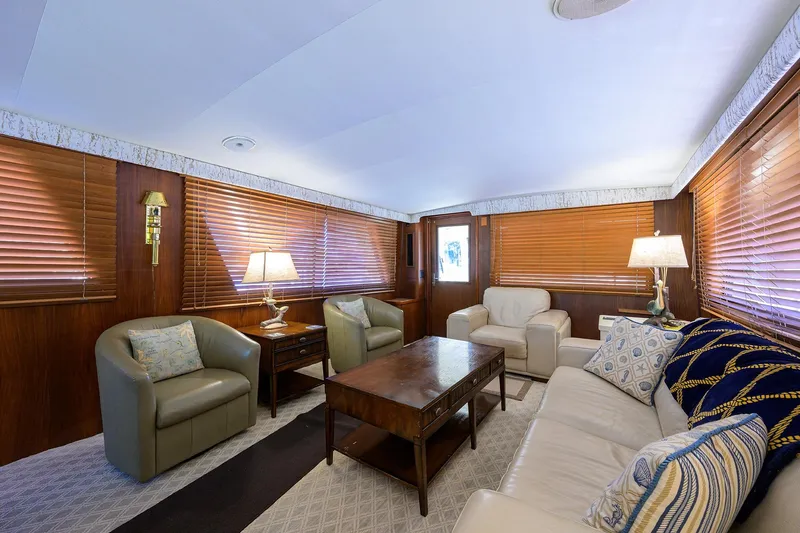 Phantom Yacht Photos Pics Luxurious interior of 1987 Hatteras 63 Motor Yacht with elegant seating and wooden blinds.