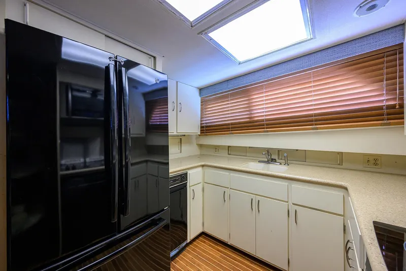Phantom Yacht Photos Pics Interior kitchen of 1987 Hatteras 63 Motor Yacht with modern appliances and wooden blinds.