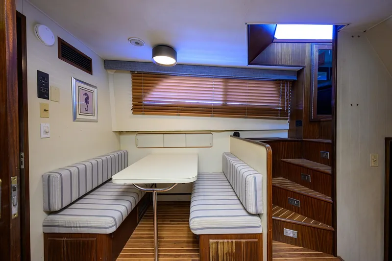 Phantom Yacht Photos Pics Interior of 1987 Hatteras 63 Motor Yacht with striped seating and wooden accents.