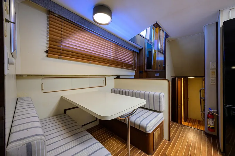 Phantom Yacht Photos Pics 1987 Hatteras 63 Motor Yacht interior with striped seating and wooden blinds.