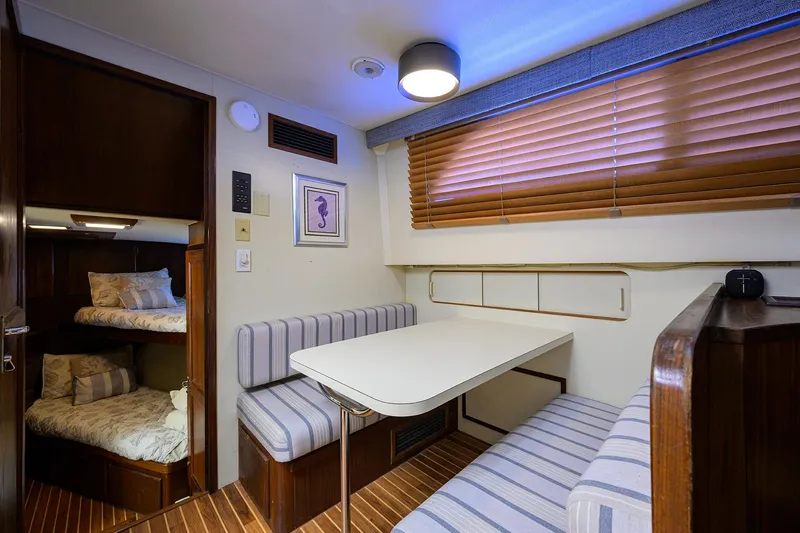 Phantom Yacht Photos Pics Interior of 1987 Hatteras 63 Motor Yacht with dining area and bunk beds.