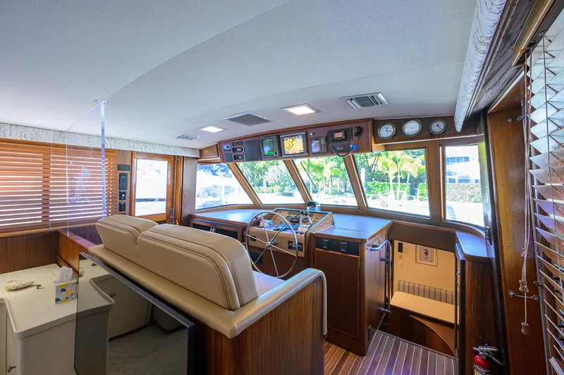 Phantom Yacht Photos Pics Interior of 1987 Hatteras 63 Motor Yacht with helm, wooden accents, and large windows.