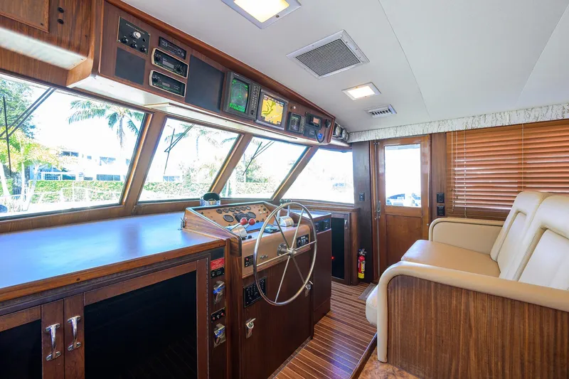 Phantom Yacht Photos Pics 1987 Hatteras 63 Motor Yacht helm with wood interior and navigation controls.