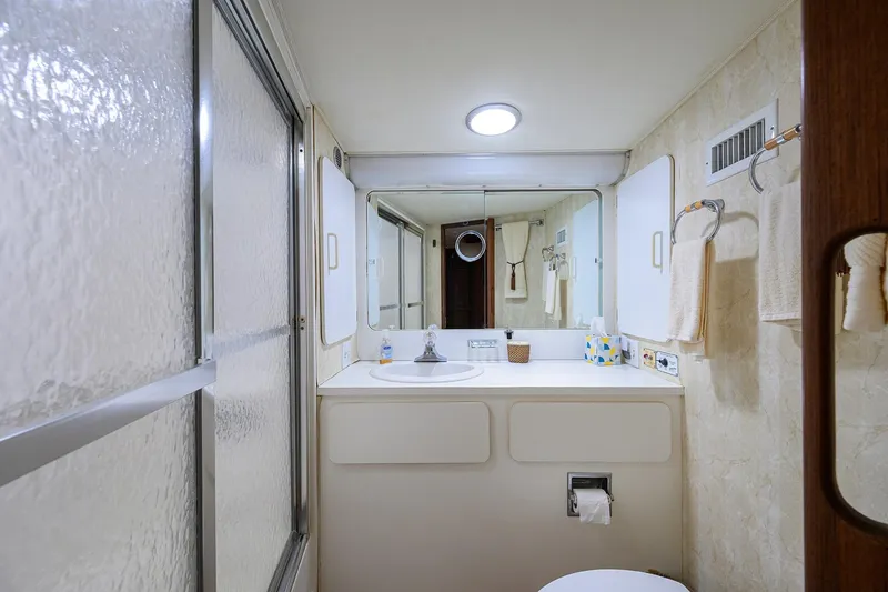 Phantom Yacht Photos Pics Bathroom interior of 1987 Hatteras 63 Motor Yacht with sink and mirror.