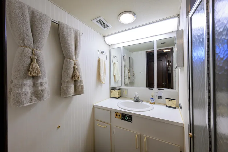 Phantom Yacht Photos Pics Luxurious bathroom in 1987 Hatteras 63 Motor Yacht with elegant towels and modern fixtures.