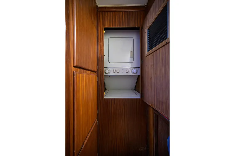 Phantom Yacht Photos Pics Laundry area with stacked washer and dryer in 1987 Hatteras 63 Motor Yacht.
