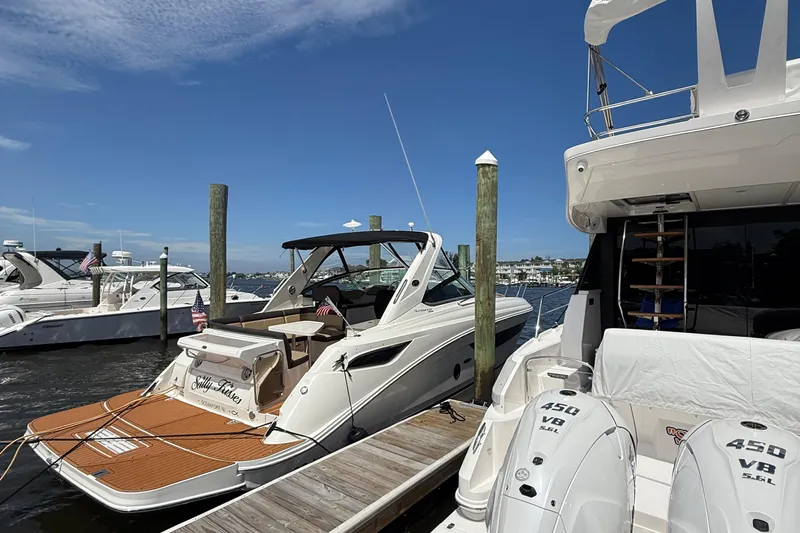  Yacht Photos Pics 2015 Sea Ray 350 Sundancer docked at marina, clear blue sky, adjacent boats visible.