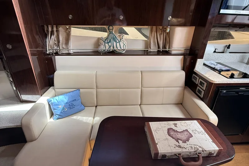  Yacht Photos Pics Luxurious interior of 2015 Sea Ray 350 Sundancer with cream sofa and nautical decor.