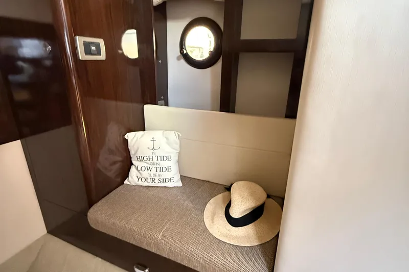  Yacht Photos Pics Interior of 2015 Sea Ray 350 Sundancer with cushion and hat on a bench.