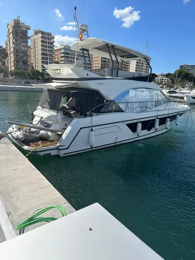 Rialtin Yacht Photos Pics 2022 Beneteau Monte Carlo 52 yacht docked in a marina with cityscape background.