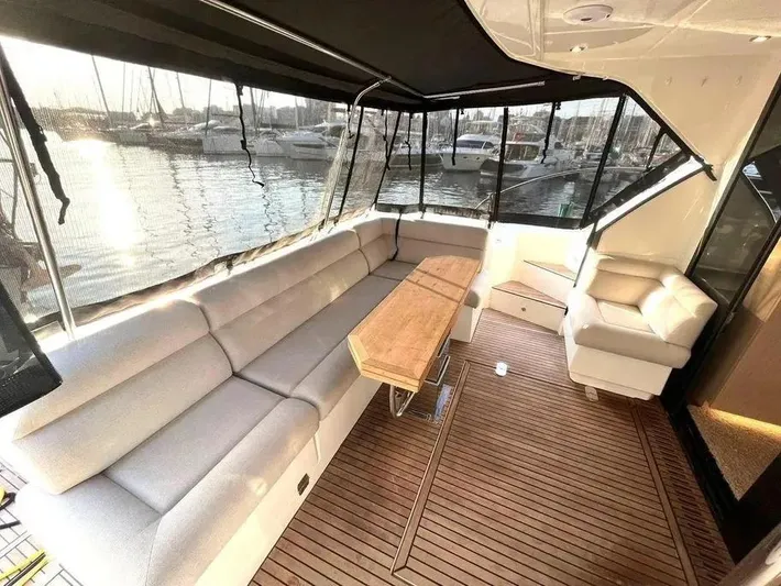 Rialtin Yacht Photos Pics Luxurious interior of 2022 Beneteau Monte Carlo 52 yacht with elegant seating and wooden flooring.