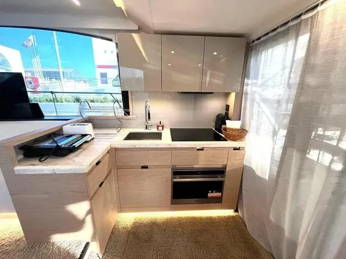 Rialtin Yacht Photos Pics Modern kitchen interior on 2022 Beneteau Monte Carlo 52 yacht, featuring sleek cabinetry and appliances.
