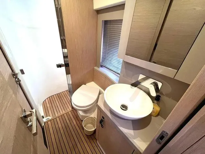 Rialtin Yacht Photos Pics Luxurious bathroom in 2022 Beneteau Monte Carlo 52 yacht with modern fixtures and wooden accents.
