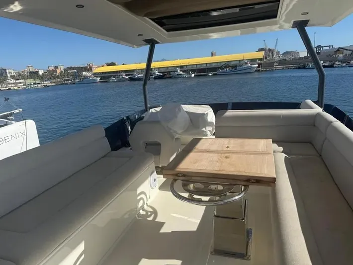 Rialtin Yacht Photos Pics Luxurious seating area on a 2022 Beneteau Monte Carlo 52 yacht, docked at a marina.