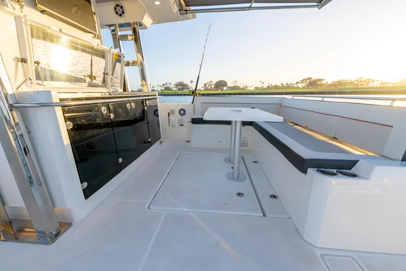  Yacht Photos Pics 2022 Jeanneau Leader 12.5 WA boat interior with seating and table, sunlit view.