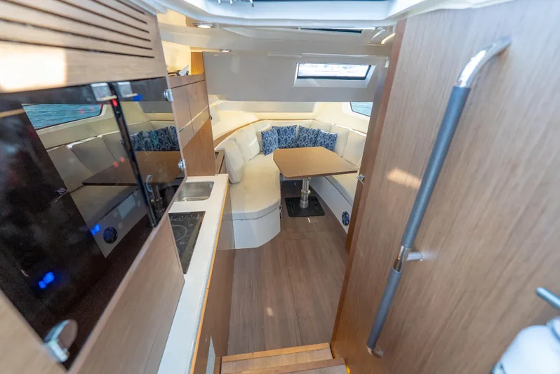  Yacht Photos Pics 2022 Jeanneau Leader 12.5 WA interior with modern kitchen and cozy seating area.