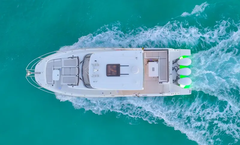  Yacht Photos Pics Aerial view of 2022 Jeanneau Leader 12.5 WA cruising on turquoise water.